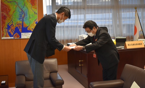 朝日健太郎・国土交通大臣政務官（左）に要望書を提出する