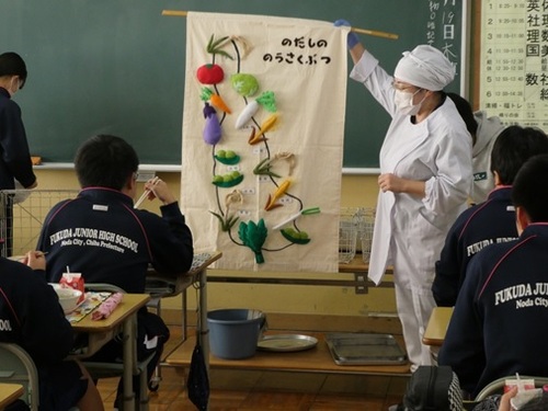 栄養教諭が児童生徒に野田産の農作物について説明している様子