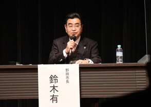 シンポジウムで発言する市長の写真