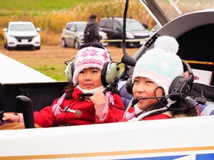 飛行機コクピットの体験搭乗をする女児