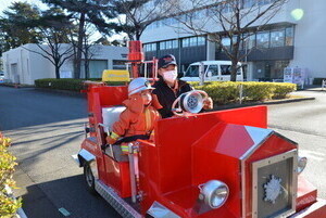 ミニ消防車に乗る子ども