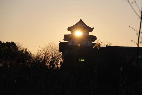 天守閣シルエットの中に太陽の輝き
