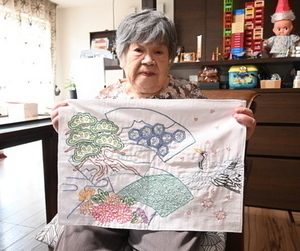 趣味の刺繍の作品を持って