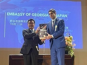 野田市特産の黒酢米を贈呈する市長