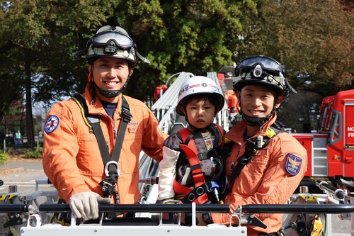 はしご車にのる子どもと消防士