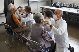 歯科医師の検診を受ける参加者たち